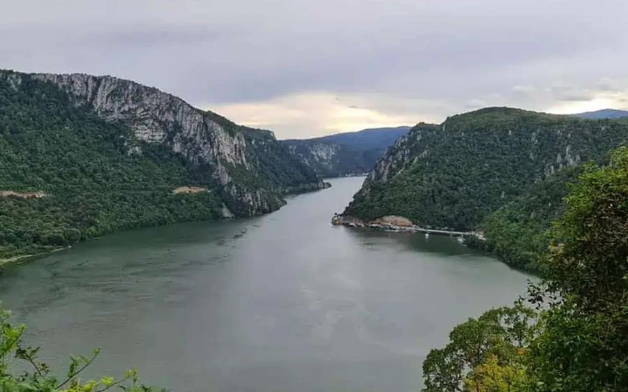 Les gorges vues d&rsquo;en haut : le fleuve coulant entre de hautes falaises boisées sous un ciel gris