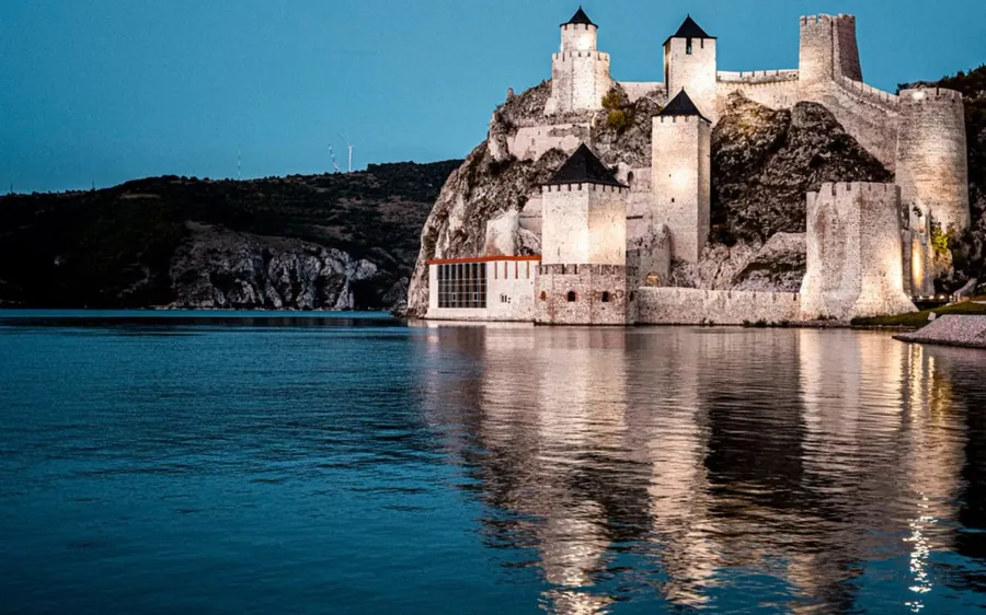 La forteresse sur sa falaise au-dessus d&rsquo;une eau bleu sombre, tours aux toits coniques noirs