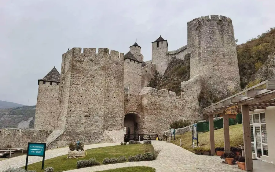 Murs de la forteresse et une porte vus depuis l&rsquo;intérieur du site, avec les bâtiments d&rsquo;accueil à côté